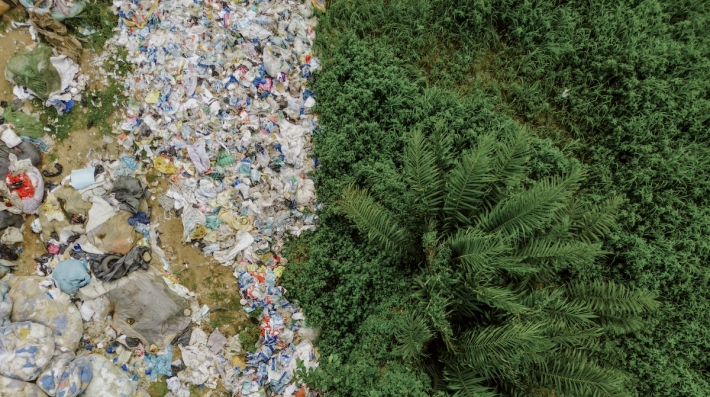 An aerial shot of waste pollution next to vegetation.